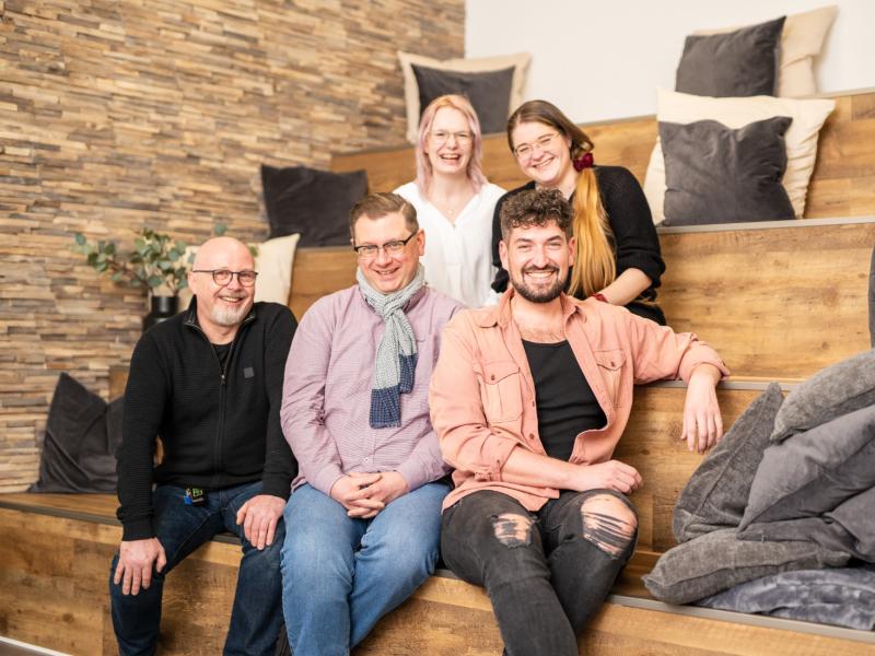 5 Mitarbeitende auf Treppe
