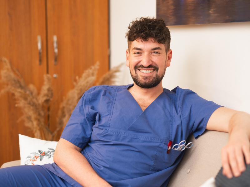 Lächelnder Krankenpfleger auf Sofa