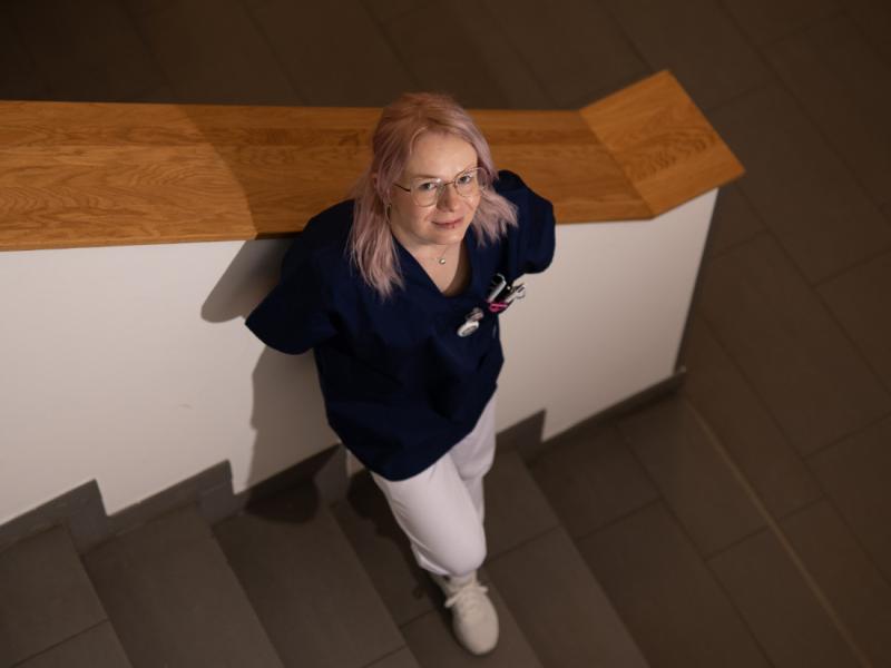 Medizinische Fachkraft steht an Treppe und schaut nach oben