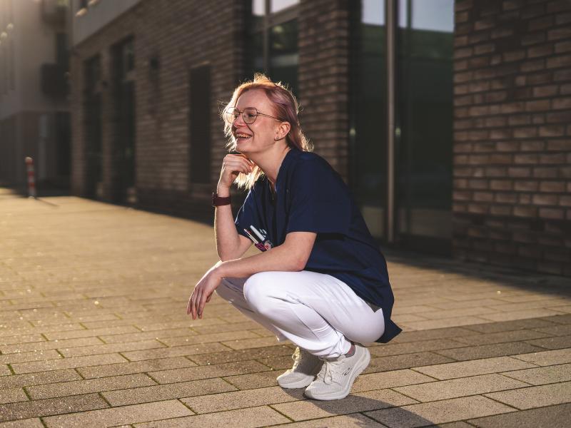 Pflegerin lachend in der Hocke